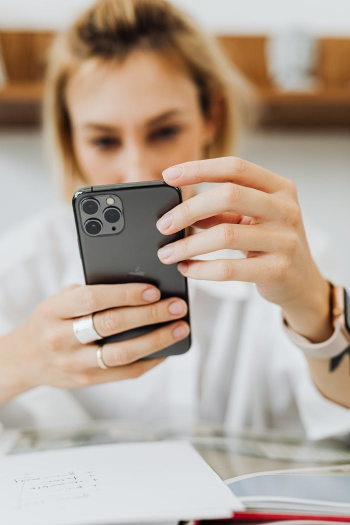Close-up of a woman holding a smartphone, focused on screen.